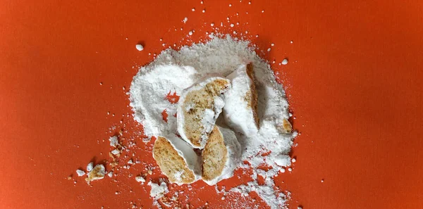 vanilla cookies crackers with sugar powder on orange background, sweet food theme.