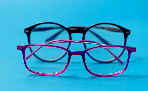 Close Van Levendige Roze Zwarte Kunststof Bril Frames Blauwe Achtergrond — Stockfoto
