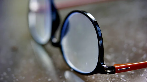 Špinavé Černé Brýle Čtení Skleněném Povrchu Stolu — Stock fotografie
