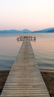 Kuzey Makedonya 'daki Prespa Gölü sahili ve ahşap iskele manzarası.