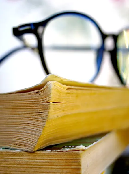 reading glasses on the top of an old books.