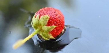 whole strawberry on a water , reflection background clipart