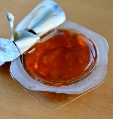 küçük yuvarlak plastik kapta bal.