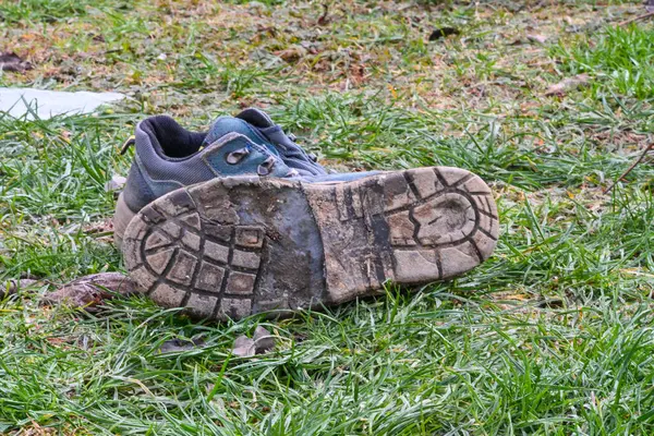 Çimlerin üzerinde eski kirli kış ayakkabıları yürüdükten sonra.