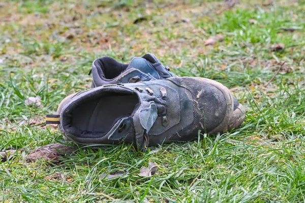 Çimlerin üzerinde eski kirli kış ayakkabıları yürüdükten sonra.