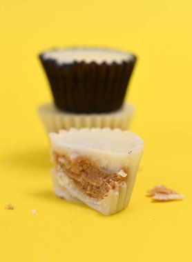 Sarı arka planda beyaz çikolata bonbonu, tatlı yemek teması.