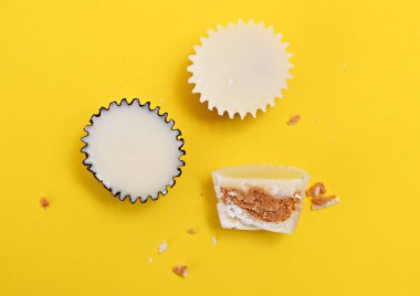 Sarı arka planda beyaz çikolata bonbonu, tatlı yemek teması.