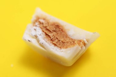 Sarı arka planda beyaz çikolata bonbonu, tatlı yemek teması.