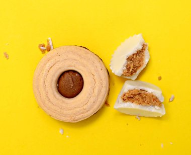 Sarı arka planda beyaz çikolata bonbonu, tatlı yemek teması.