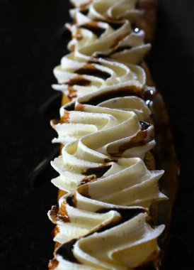 Taze baket rulo ev yapımı kek siyah bir tabakta.