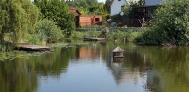 Handmade  pond and wooden piers in  Lithuanian  village