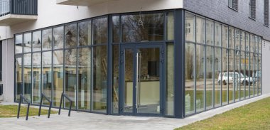 Konut binasının birinci katındaki yeni bir ofisin cam pencereleri.