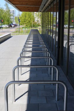 Modern bir okulun yakınında bisiklet ve scooterlar için park yerleri