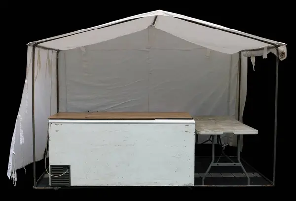 White canvas tent with  refrigerator on the street.  Isolated on black