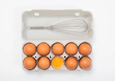 Kahverengi çiğ yumurta kağıt tepside çırpılmış beyaz arka planda.