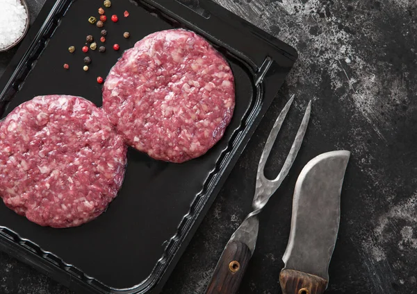 Raw Beef Burgere Forseglet Vakuumbrett Med Grillgaffel Kniv Mørkt Kjøkken – stockfoto