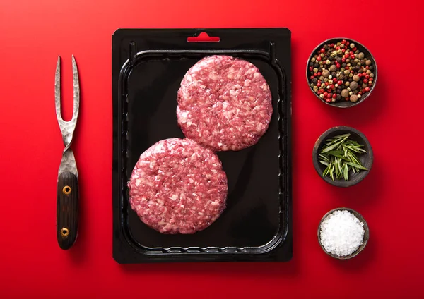 Beef Burgers Vacuum Tray Fork Salt Pepper Red Background Top — Photo