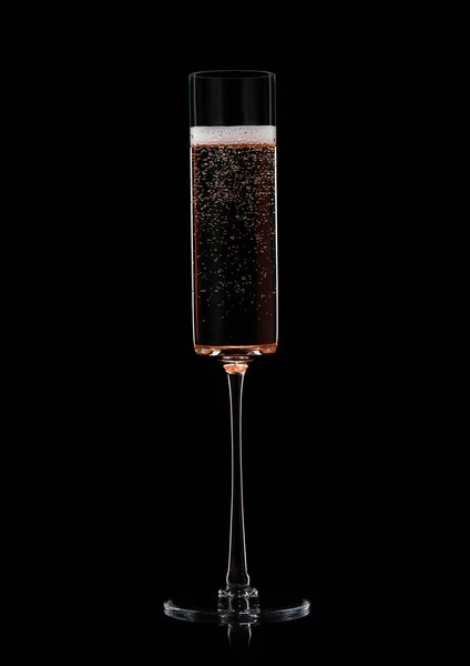 Rose pink champagne in fine crystal glass with bubbles on black.