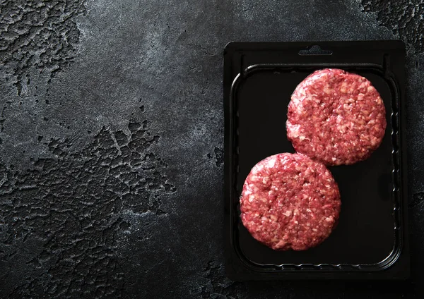 Rauwe Gehakte Rundvlees Hamburgers Plastic Vacuüm Lade Zwarte Steen Achtergrond — Stockfoto
