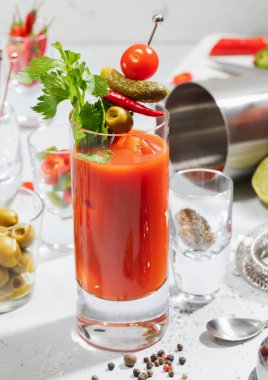 Limonlu, zeytinli, biberli ve kokteyl karıştırıcılı Bloody Mary bardağı.