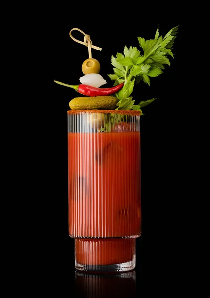 Bloody mary cocktail with stick and various snack on black.Olive,pepper,onion,celery,pickle
