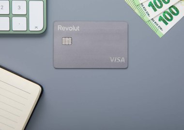 LONDON, İngiltere - 18 Kasım 2022: Revolut vizesiz erişim kartı üzerinde bitcoin, klavye ve 100 euro fatura var. Üst görünüm.