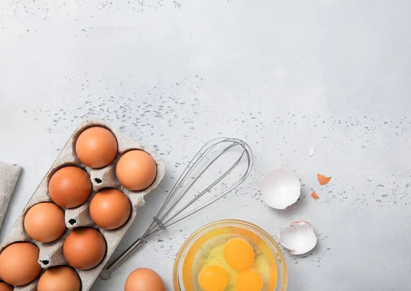 薄いキッチンテーブルの上に黄身 泡立て器とシェルと有機茶色の卵 — ストック写真