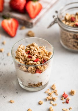 Çilekli ev yapımı granola ve beyaz üzerine doğal Yunan usulü yoğurt..