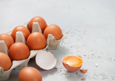 Sarı yumurtalı organik kahverengi tepsi, çırpma ve kabuk açık mutfak masasında..