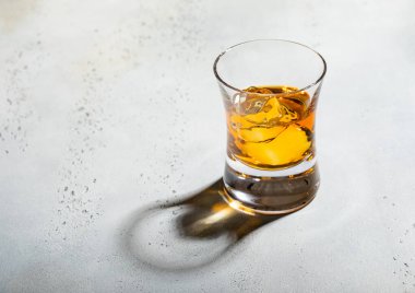 Arka planda buz küpleri olan lüks bir viski bardağı. Üst manzara..