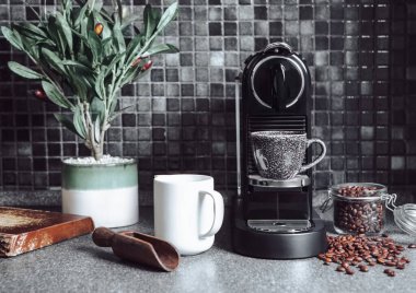 Kahve makineli mutfak, sabah kahvaltısı için kepçeli çiğ fasulye ve beyaz bardak.