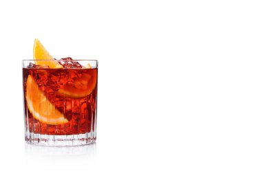 Kristal bardakta Negroni Kokteyli, buz küpleri ve beyaz arka planda portakal dilimleri. Metin için boşluk