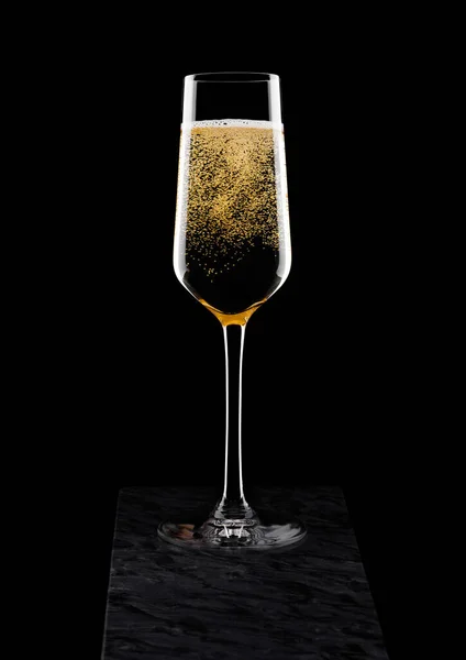黑色大理石板上的泡沫与黄色香槟的优雅玻璃 — 图库照片