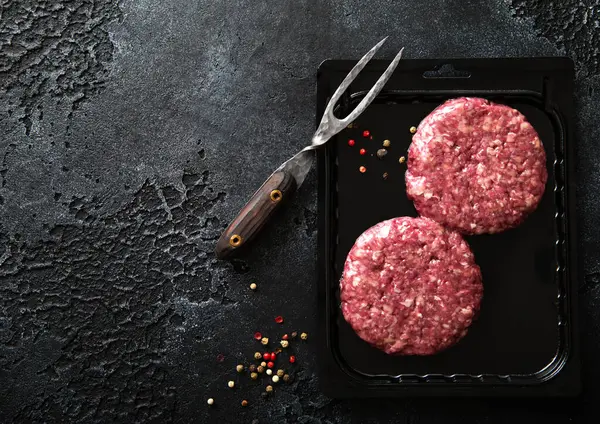 Raw Minced Beef Burgers Plastic Vacuum Tray Black Stone Background — Stock Photo, Image