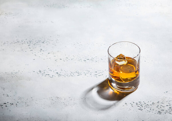 Two whiskey glass with ice cubes on light background.Top view.