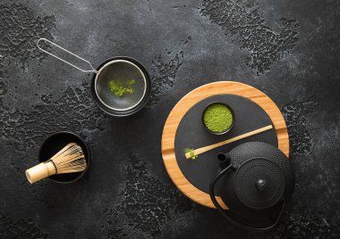 Japon demir çaydanlığı ile kibrit tozu yeşil çay tozu çırpı ve kaşık ve kase ile siyah elek.