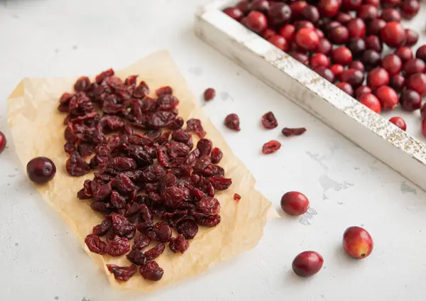 Dried cranberries with ripe cranberries in wooden box.