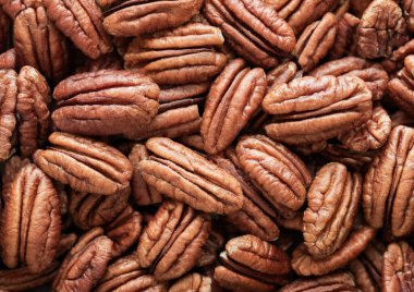 Raw peeled brown pecan nuts top view macro background. clipart