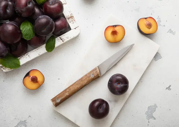 Mutfak Arka Planında Mutfak Bıçağıyla Olgunlaşmış Mor Erik Dolu Ahşap - Stok İmaj