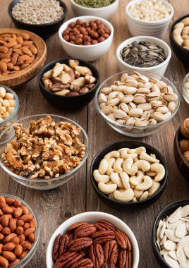 Çiğ ceviz ve bademli kaju ve çeşitli kâselerde organik fındık ve tohum..