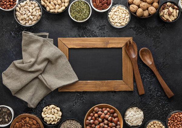 Peanut,hazelnut,walnut,almonds,pistachio,sunflower,pumpkin,chia,pecan and cashew mixed healthy nuts and seeds with menu board and kitchen utensils.