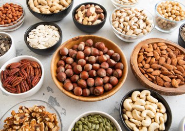 Fındık, ceviz, ceviz, ceviz, badem, fıstık, ayçiçeği ve balkabağı tohumlu kaseler. Sağlıklı beslenme atıştırmalıkları..