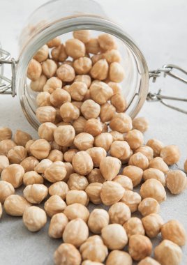 Beyaz mutfak masasında cam kavanozda çiğ fındık çerezi..