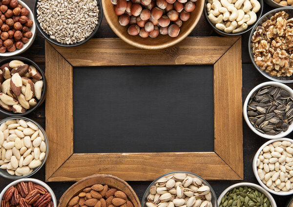 Peanut,hazelnut,walnut,almonds,pistachio,sunflower,pumpkin,chia,pecan and cashew mixed healthy nuts and seeds with menu board.