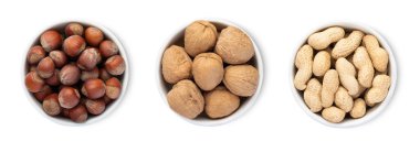 Fındık ve cevizli kase tabakları ve beyaz arka planda kabuklu fıstık..