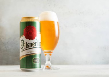 LONDON, İngiltere - 20 Şubat 2025: Pilsner Urquell Çek birası bardağı alüminyum teneke ışıklı masa.
