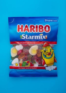 LONDON, UK - 19 HAZİRAN 2025: Haribo Starmix renkli jöle jelibonları ve en popüler şekerler mavi üzerine.