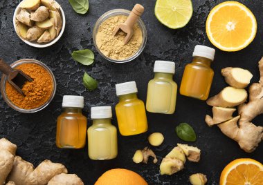 Bağışıklık sistemli zencefilli enerji içeceği taze zencefil kökleri ve siyah arka planda portakal meyveleri..