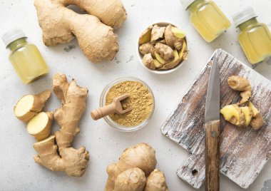 Bağışıklık sistemi kızıl enerjili içecek şişeleri taze zencefil kökü ve hafif arka planda toz..