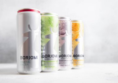 LONDON, İngiltere - 24 Şubat 2025: Hafif arkaplanda çeşitli aromalı Borjomi Gürcistan maden suyu konserveleri.